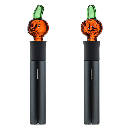 Two orange Pumpkin Jack glass attachments for the Pivot device featuring carved face details and green stem mouthpieces on a white background.